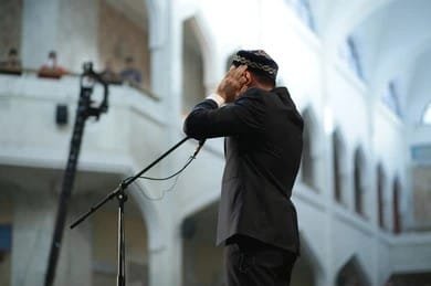 "Adhan call to prayer, Mu'adhin proclaiming from mosque minaret"
